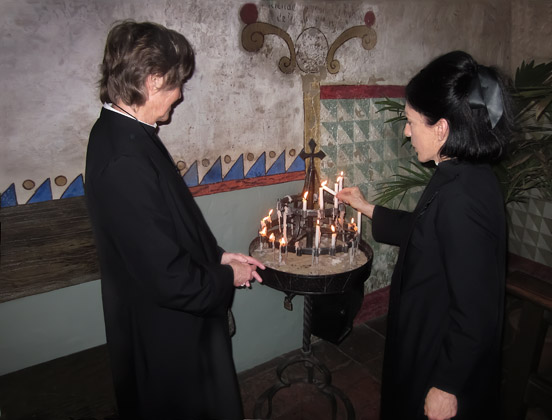 Lighting candles in the chapel of Mission Carmel